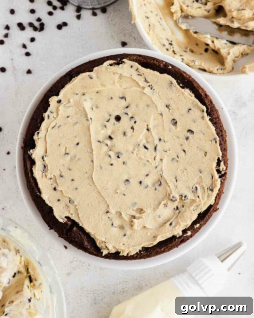 spreading edible cookie dough on top of brownie layer, filling the natural well