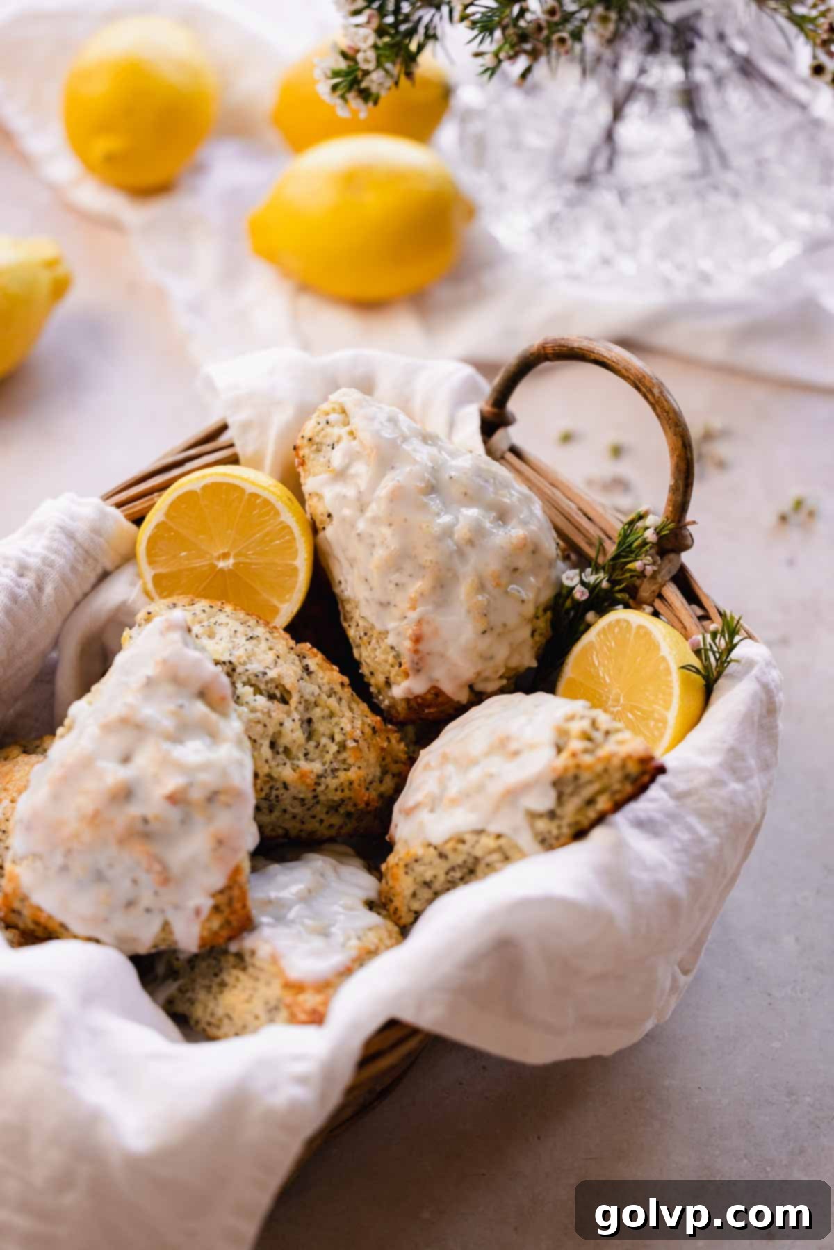 Baked lemon poppy seed scones arranged beautifully in a rustic basket lined with a towel