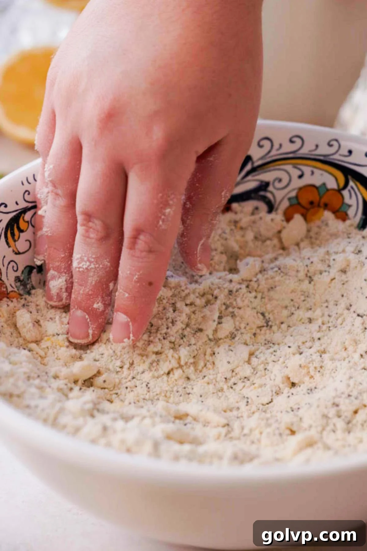 Cutting frozen butter into the dry flour mixture using fingertips for lemon poppy seed scone dough
