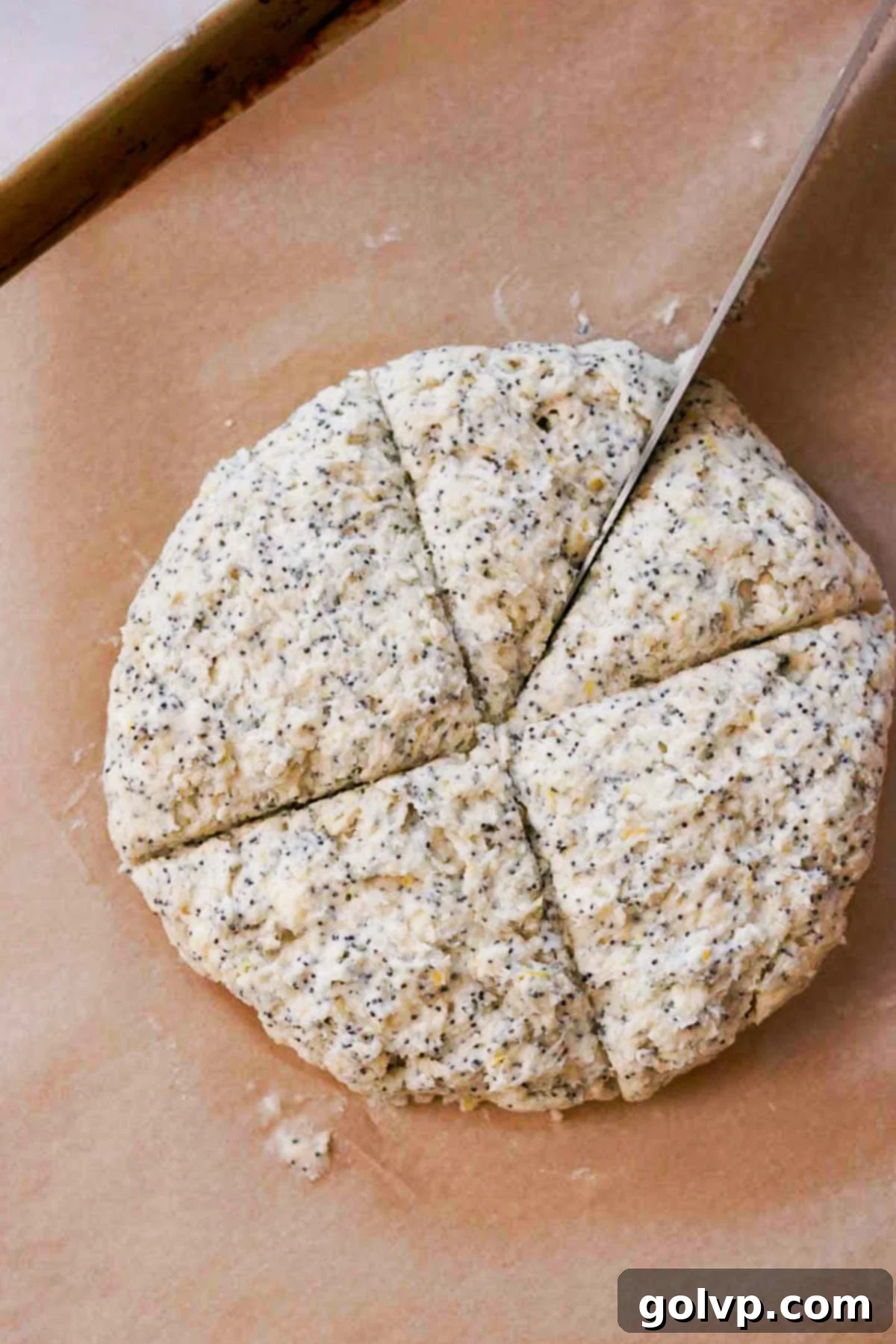 Cutting chilled scone dough into eight equal wedges on parchment paper