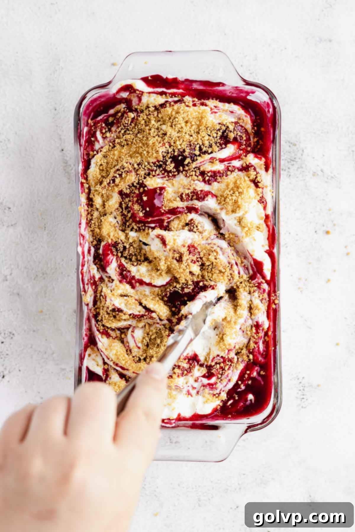 Close-up of the layering and swirling process of the no-churn ice cream in a loaf pan