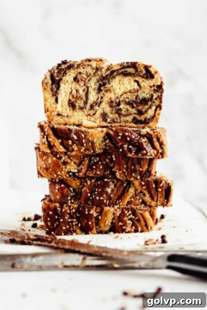 Easy No-Knead Chocolate Tahini Babka 3 Slices of chocolate tahini babka stacked on a plate, showing the intricate swirls