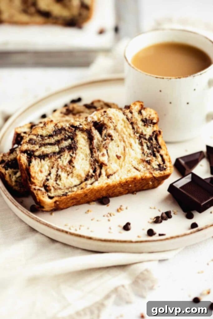 Easy No-Knead Chocolate Tahini Babka 5 Slices of chocolate tahini babka on a wooden board, with a cup of coffee