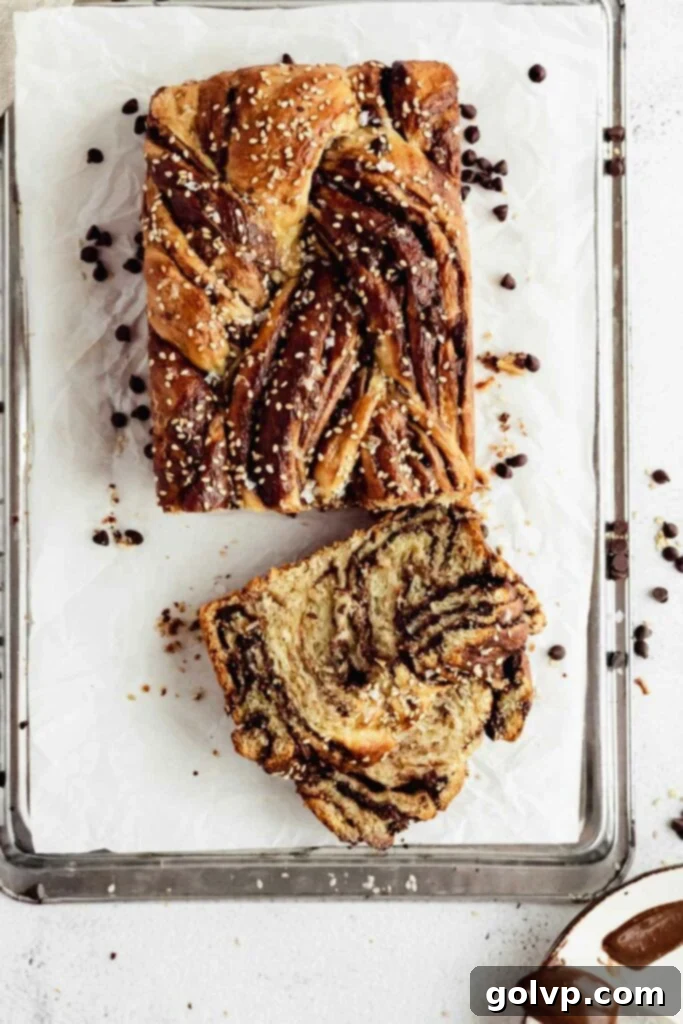 Easy No-Knead Chocolate Tahini Babka 6 Hand slicing a freshly baked chocolate tahini babka