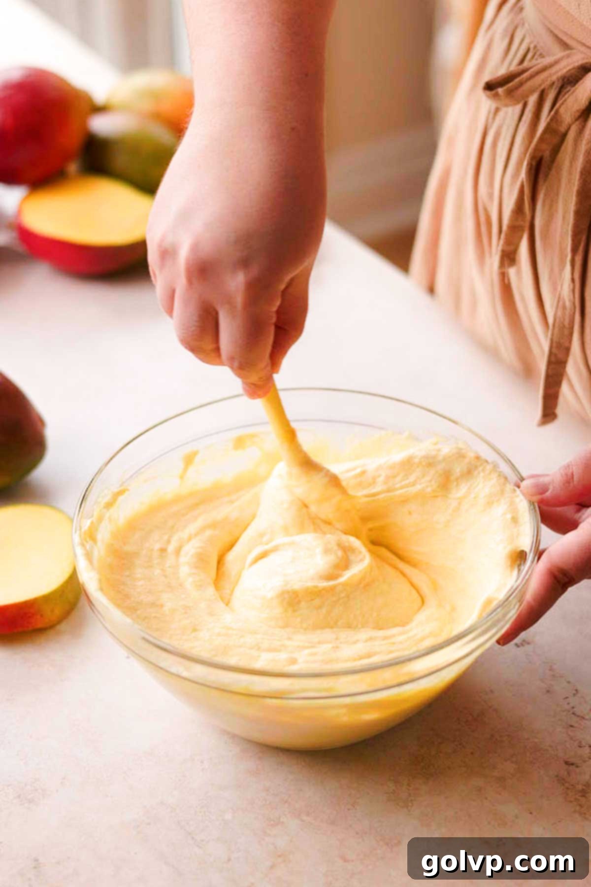 Decadent Mango Crepe Cake, Made Easy 13 Gently folding mango puree into whipped cream with a spatula.