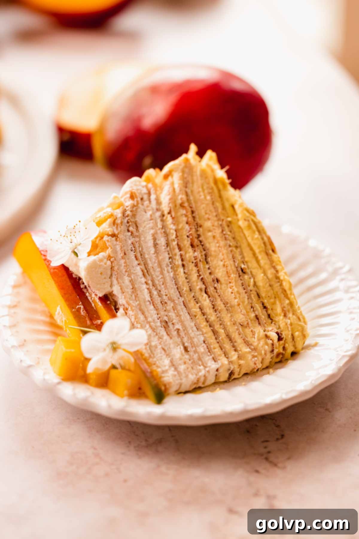 Decadent Mango Crepe Cake, Made Easy 3 A close-up view of a slice of mango crepe cake, showing the perfectly layered crepes and creamy filling.
