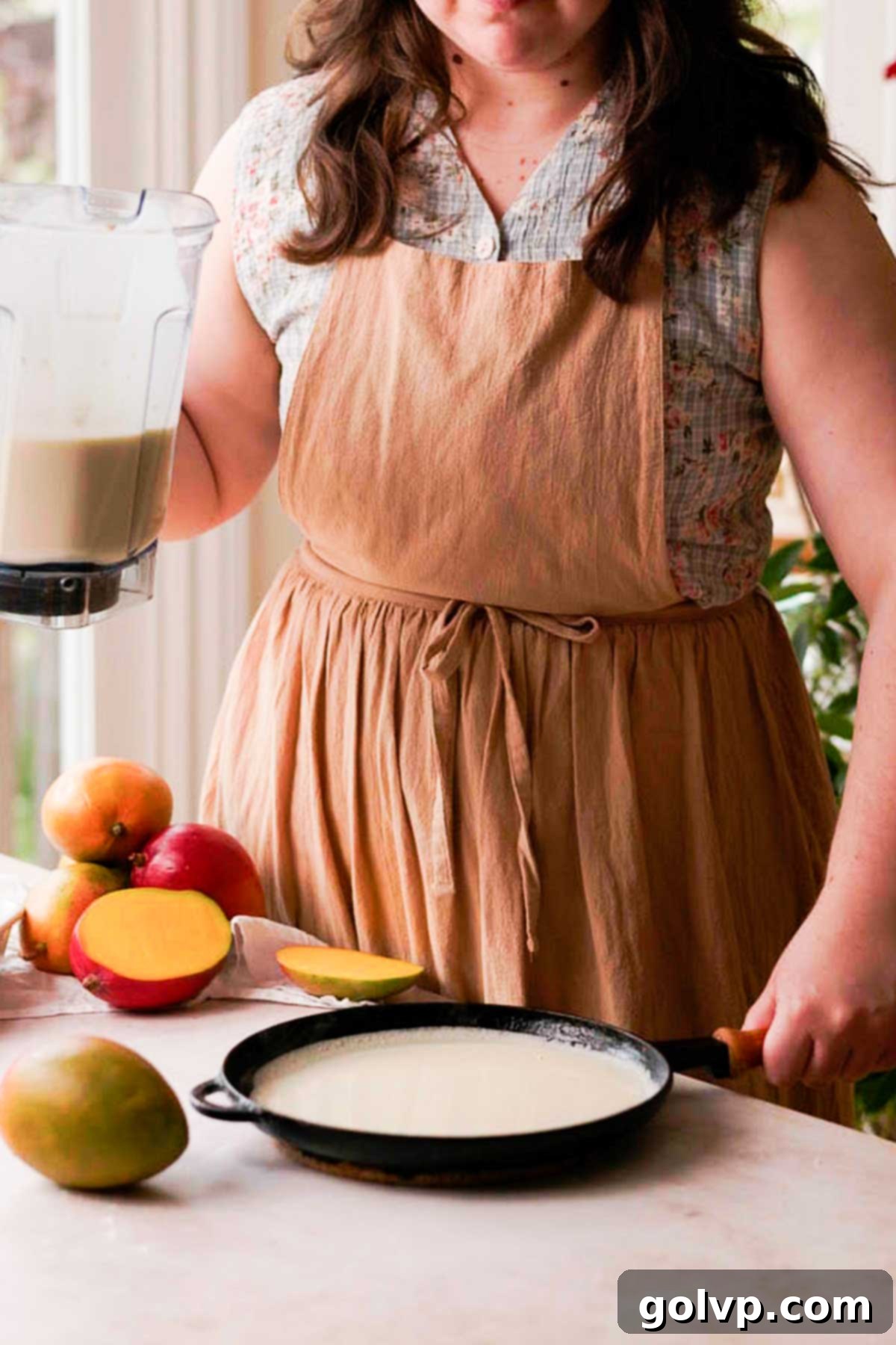 Decadent Mango Crepe Cake, Made Easy 7 Pouring crepe batter onto a hot cast iron pan.
