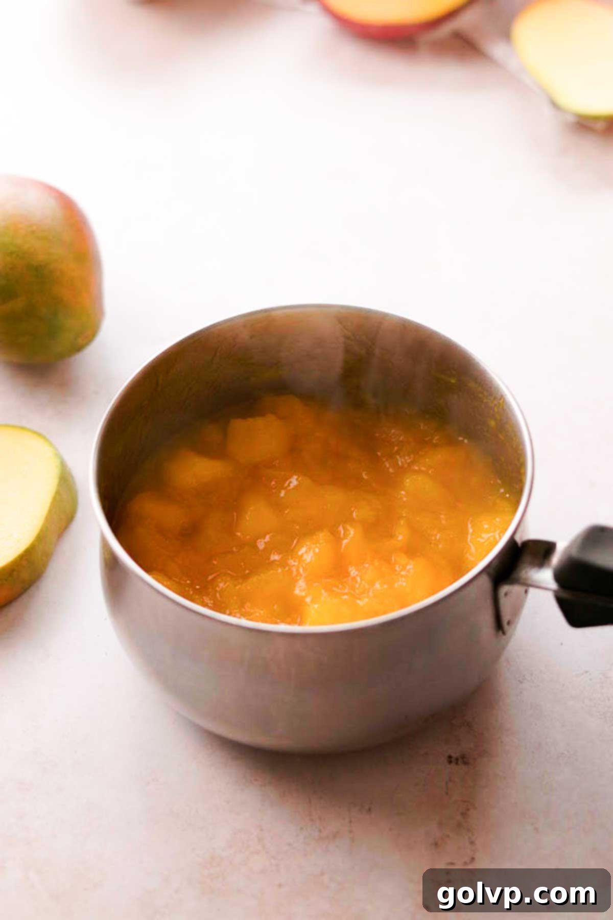 Decadent Mango Crepe Cake, Made Easy 9 Hot mango puree bubbling gently in a saucepan.