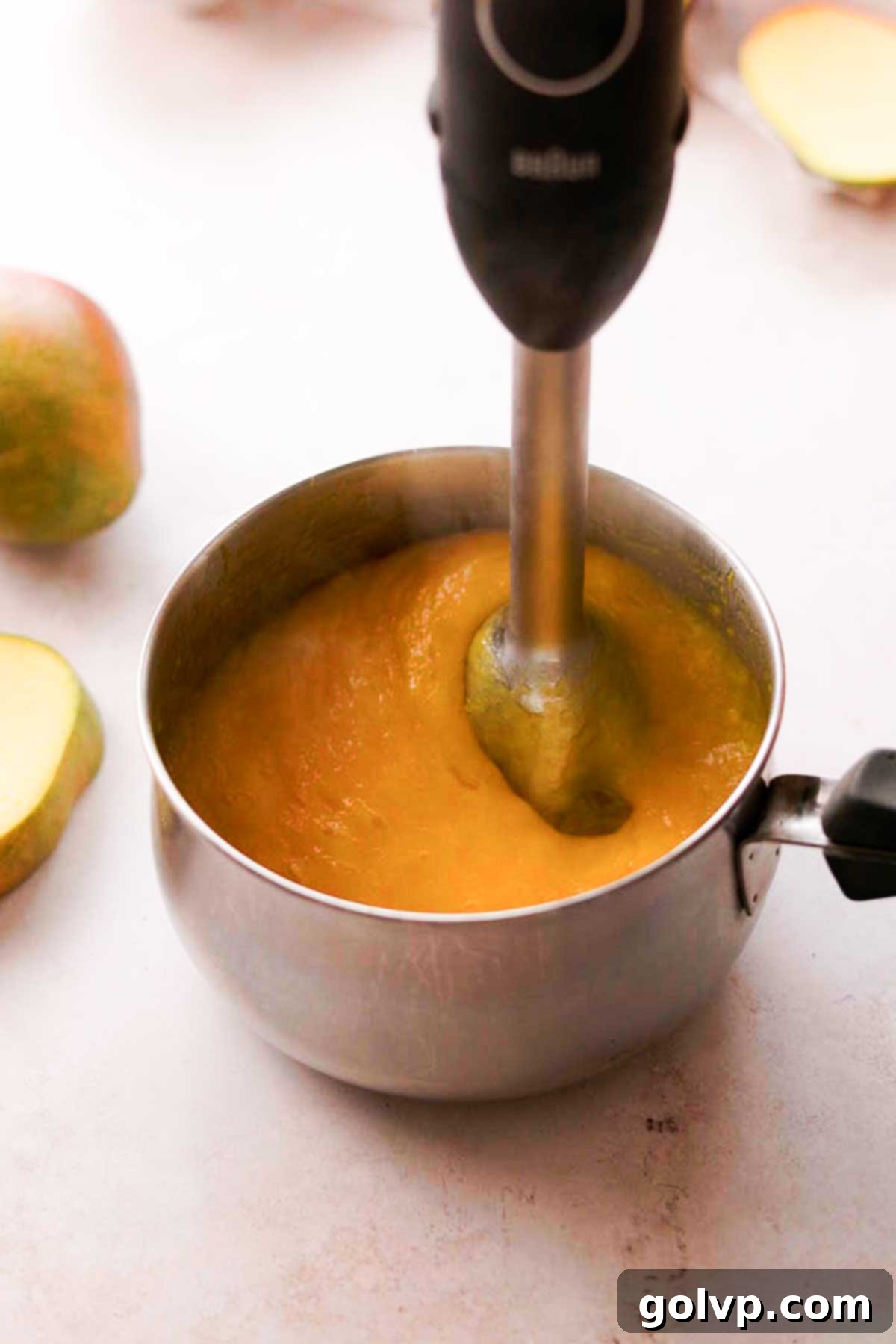 Decadent Mango Crepe Cake, Made Easy 10 Blending smooth mango puree with an immersion blender in a saucepan.