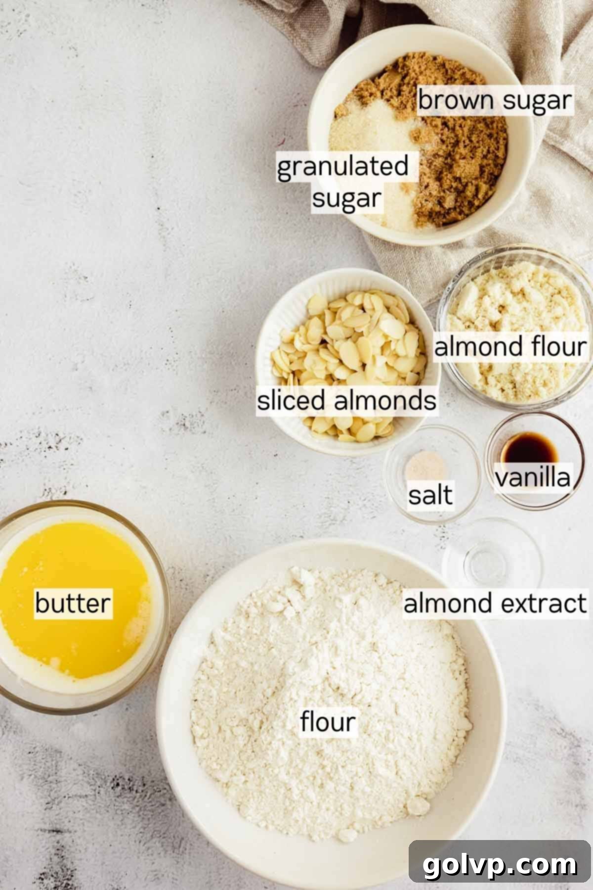 Bowls of fresh strawberries, flour, sugar, and almonds – key ingredients for strawberry crumble.