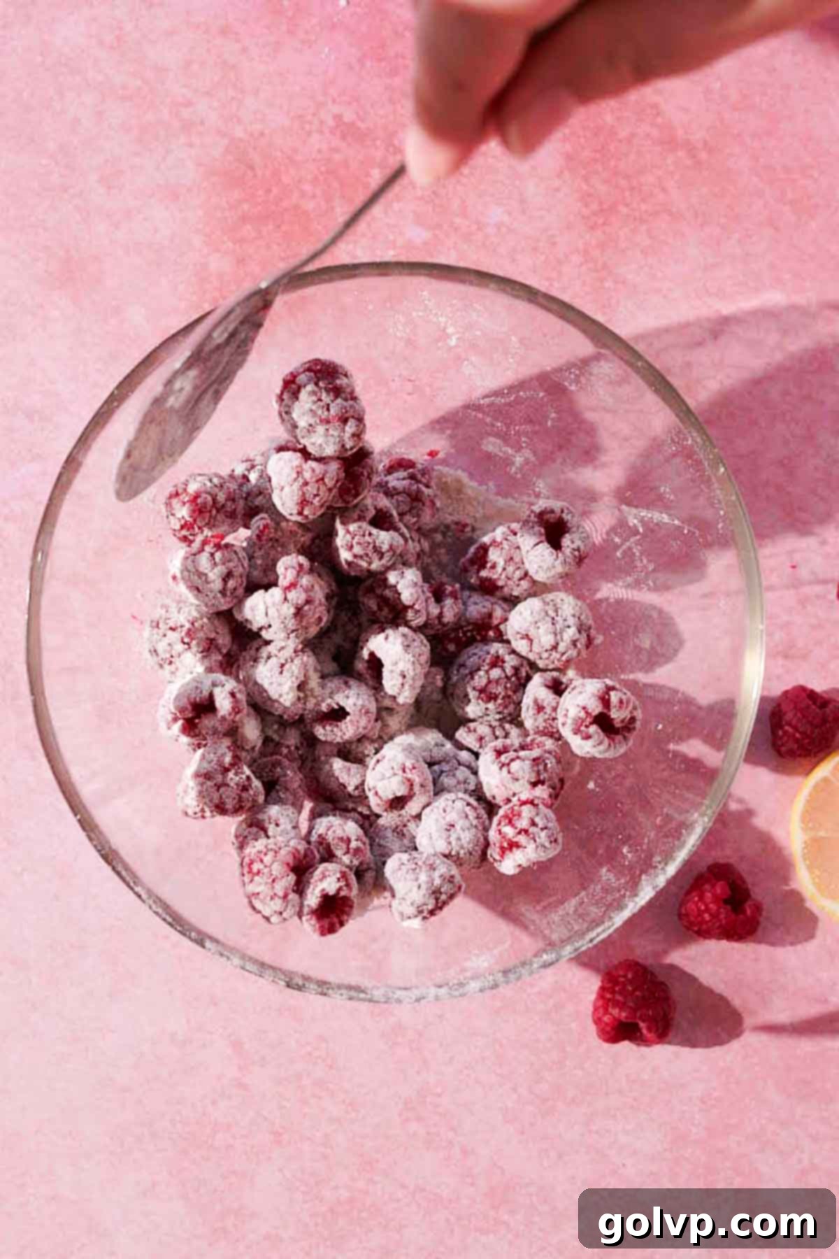 fresh raspberries coated in flour in a glass bowl