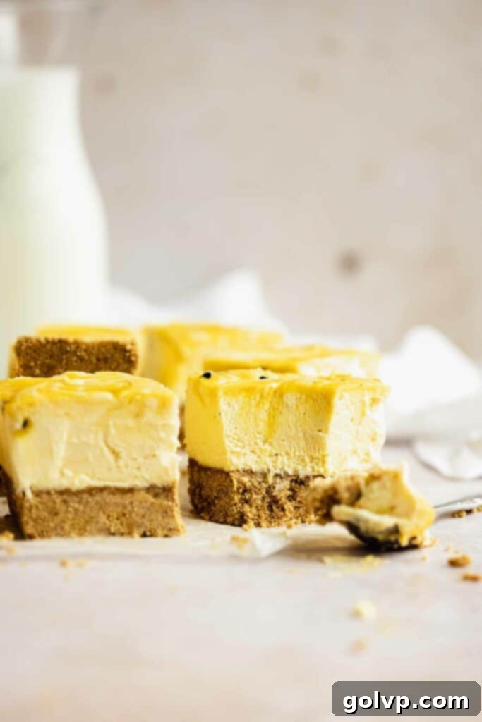 A slice of no-bake passion fruit cheesecake with a graham cracker crust and yellow passion fruit curd swirls.