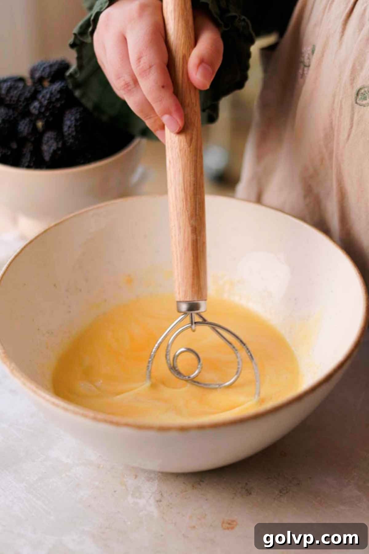 Whisking melted butter, oil, vanilla, lemon juice, salt, and buttermilk into the egg and sugar mixture.