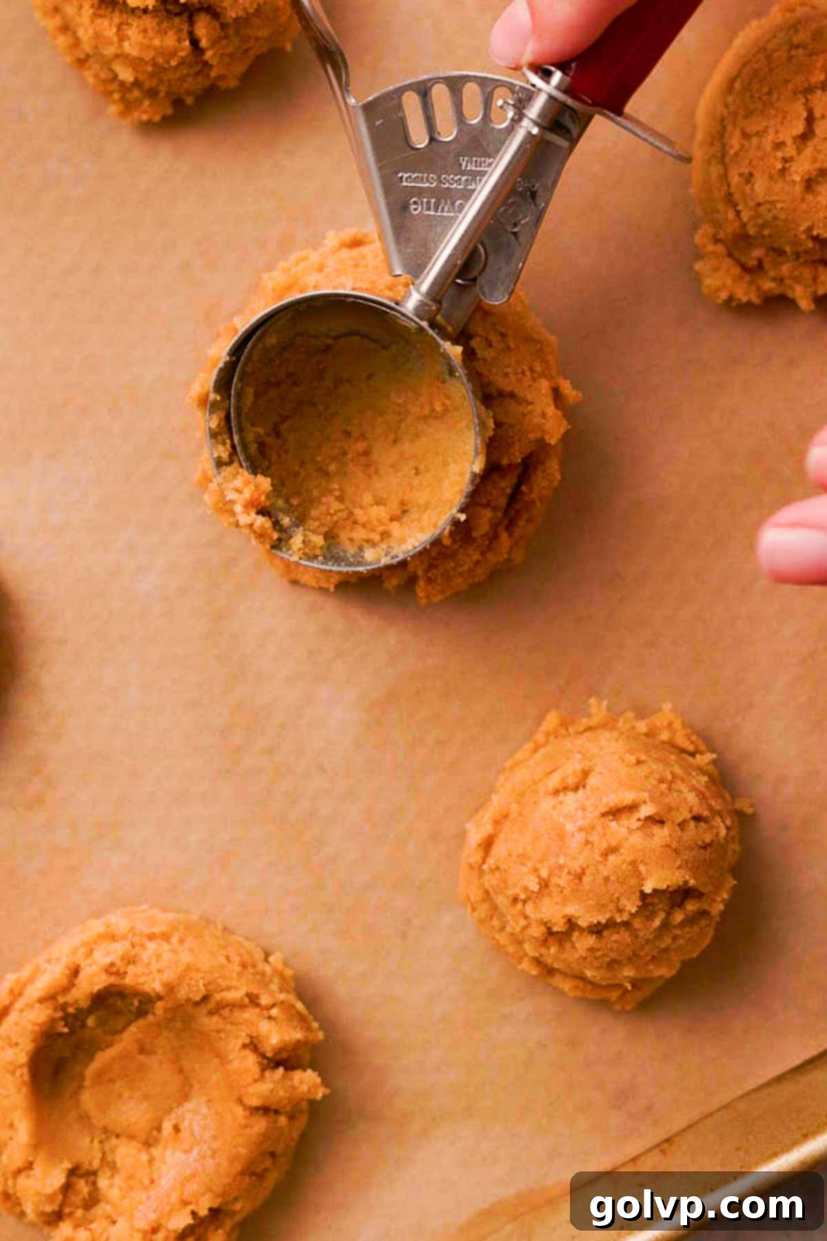 press cookie dough balls with the back of a cookie scoop