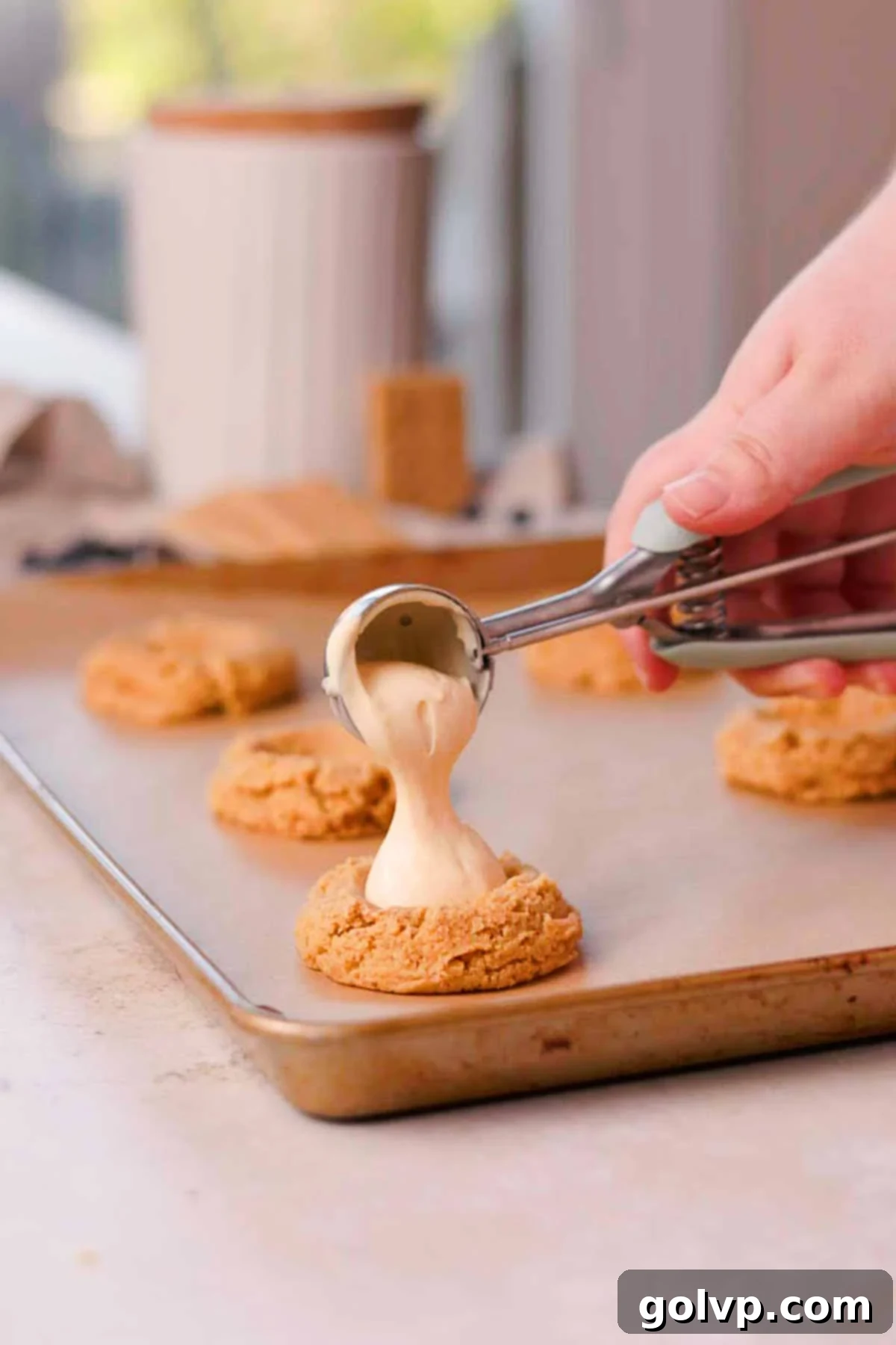 scoop cheesecake filling into cookie dough with a metal scoop