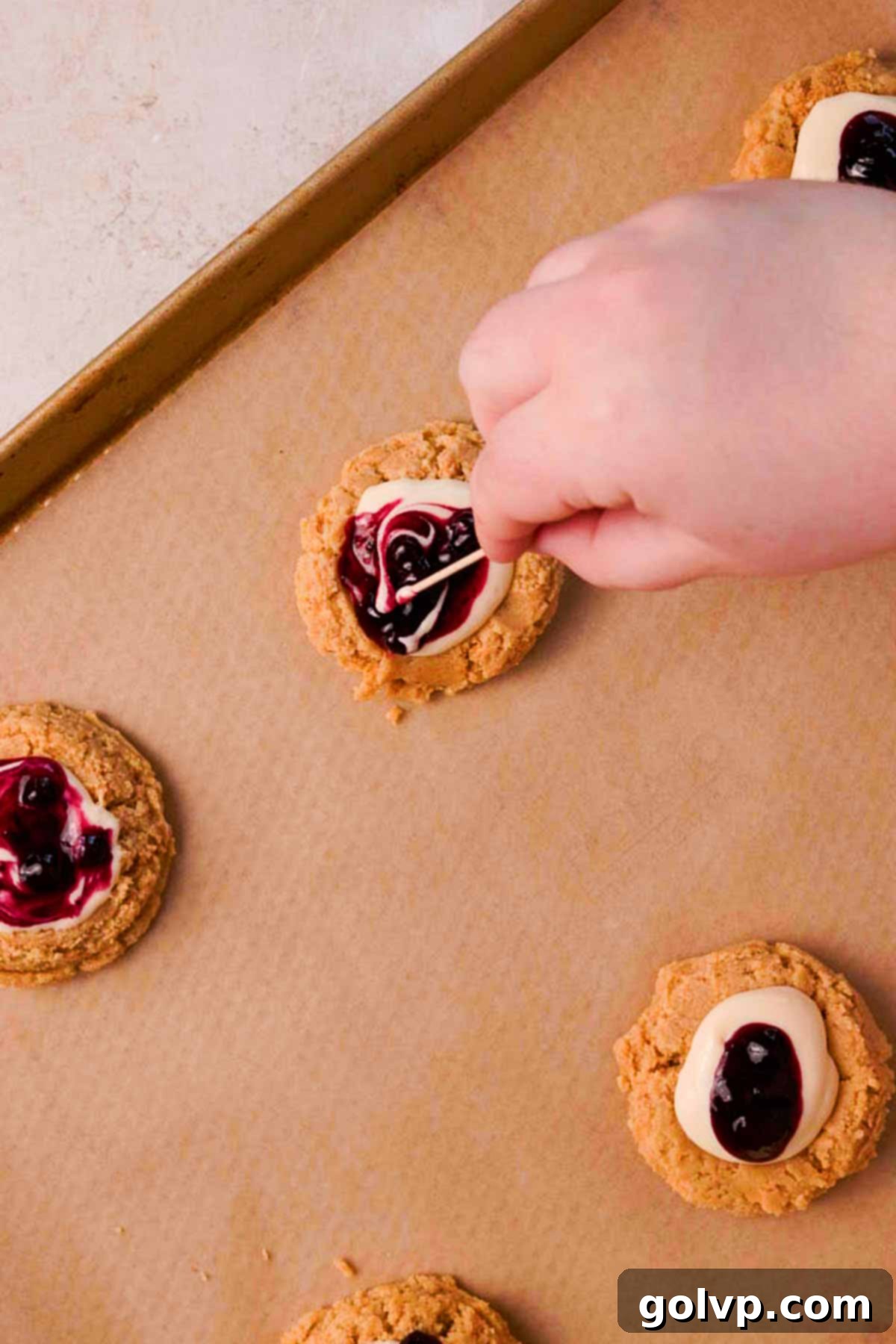 swirl blueberry and cheesecake mixture in the middle of the cookie