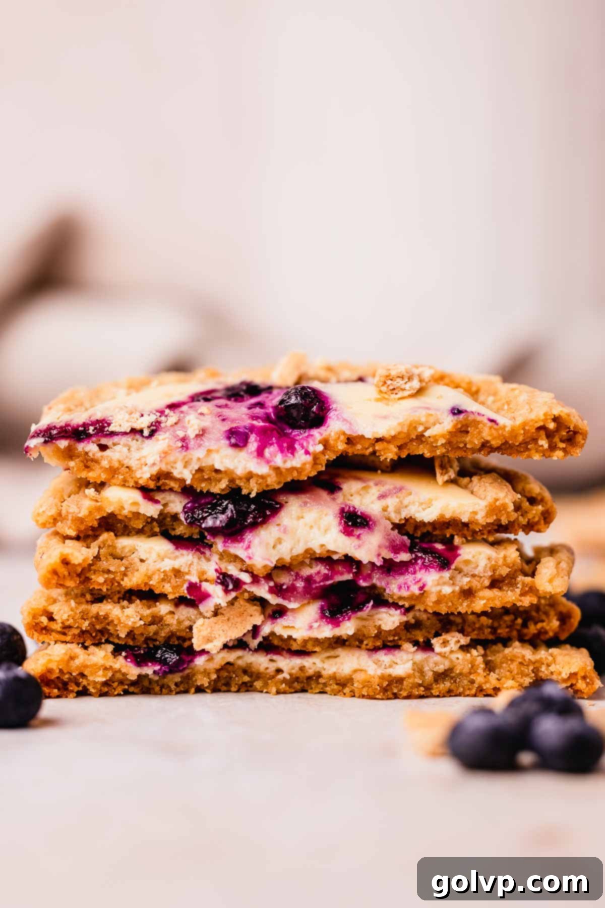 stack of blueberry cheesecake cookies cut in half to show cheesecake filling