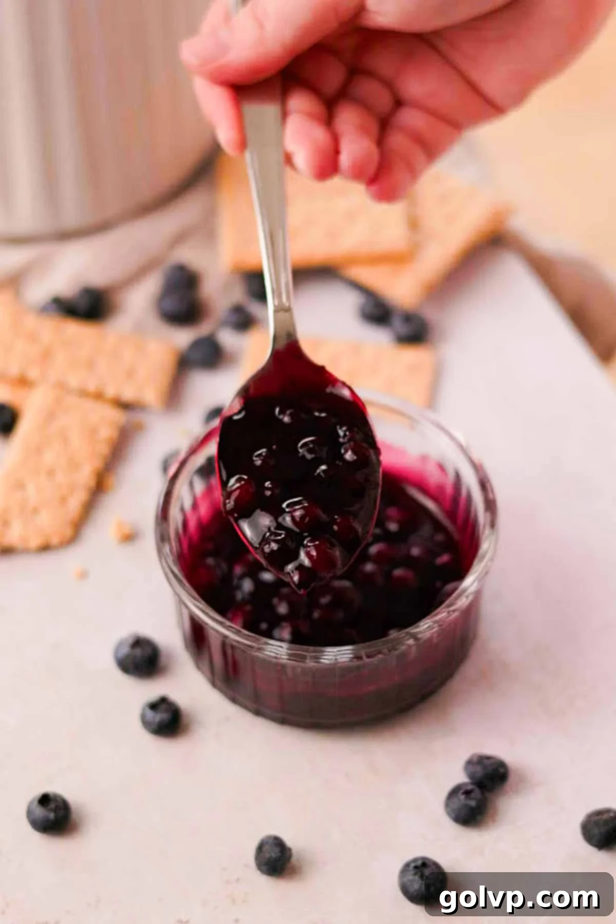 cooked thickened blueberry sauce in a spoon