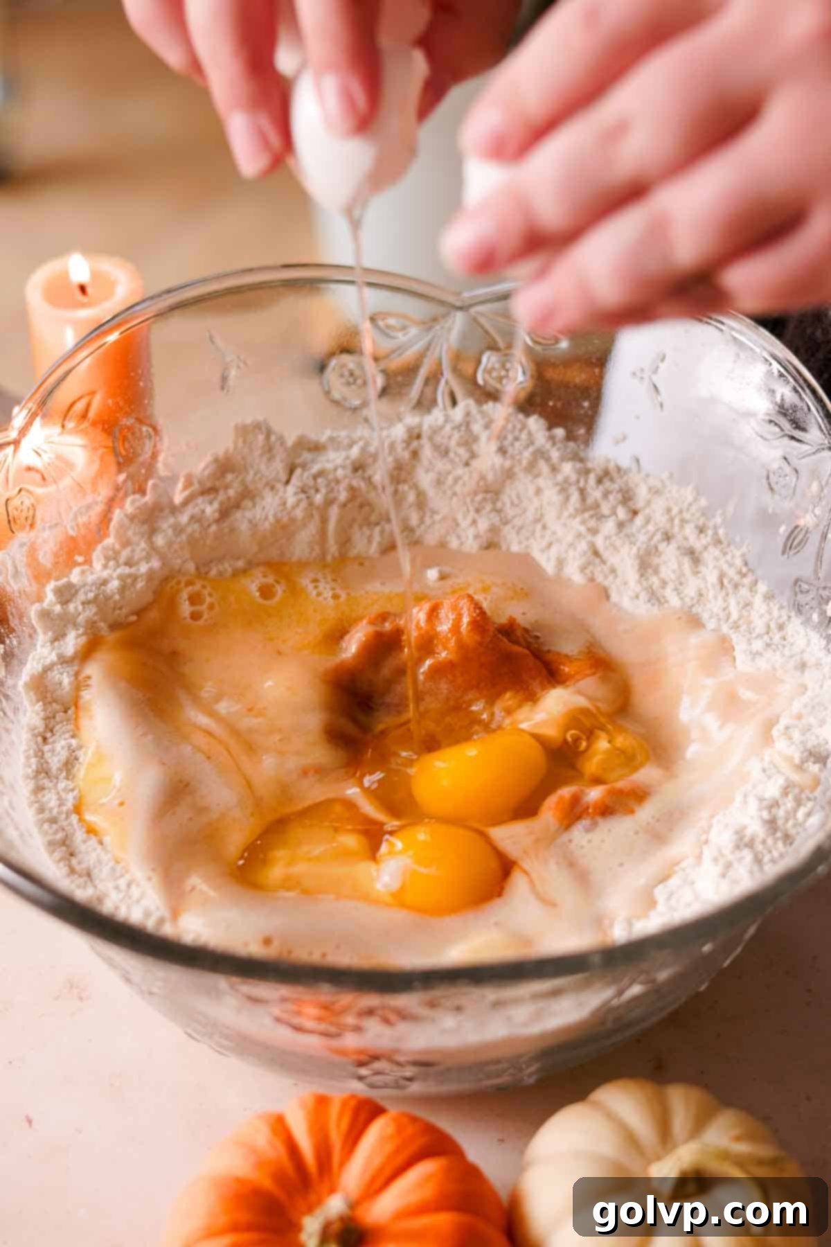 cracking eggs into a well made in the middle of dry ingredients