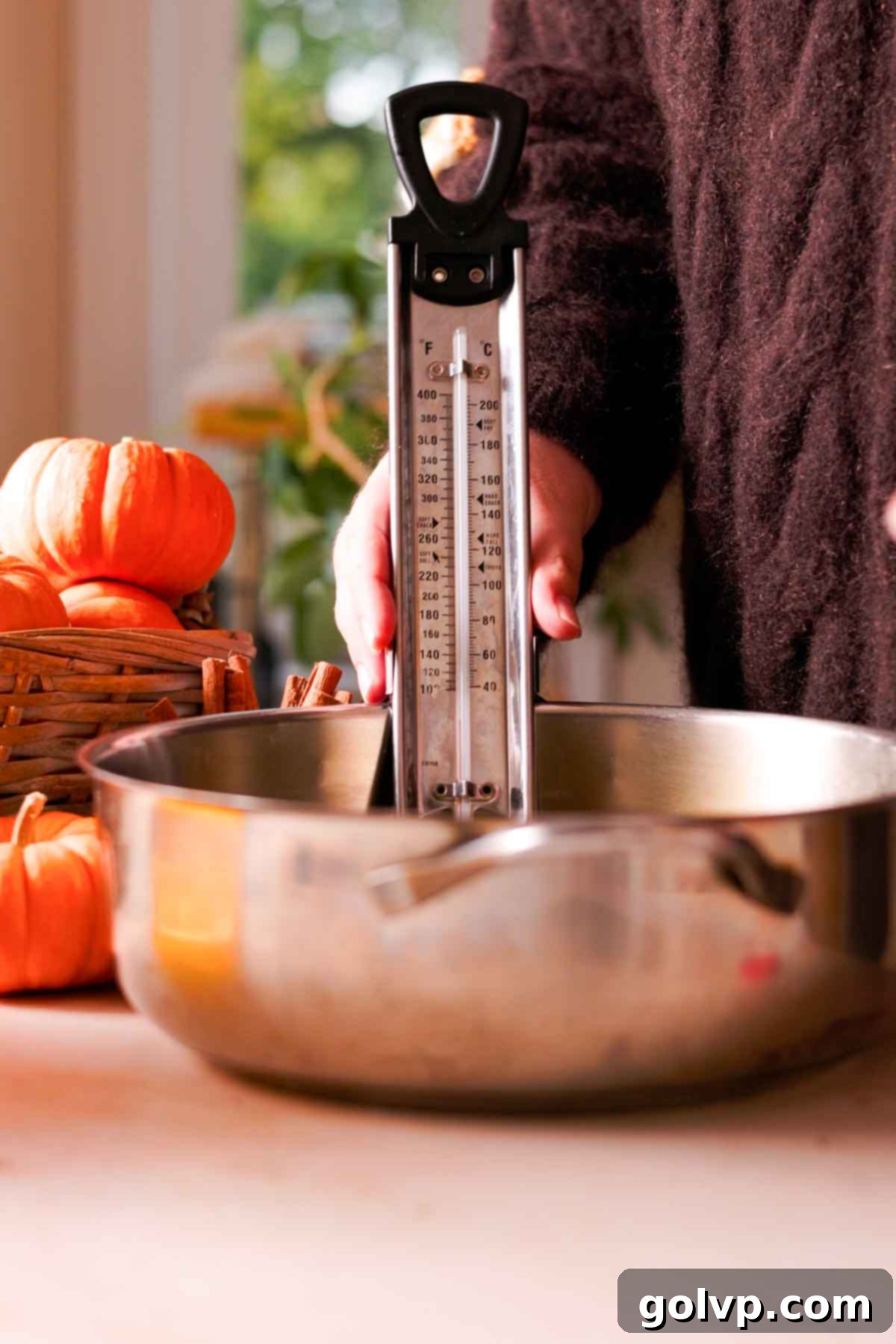 placing metal candy thermometer in a metal pot full of oil