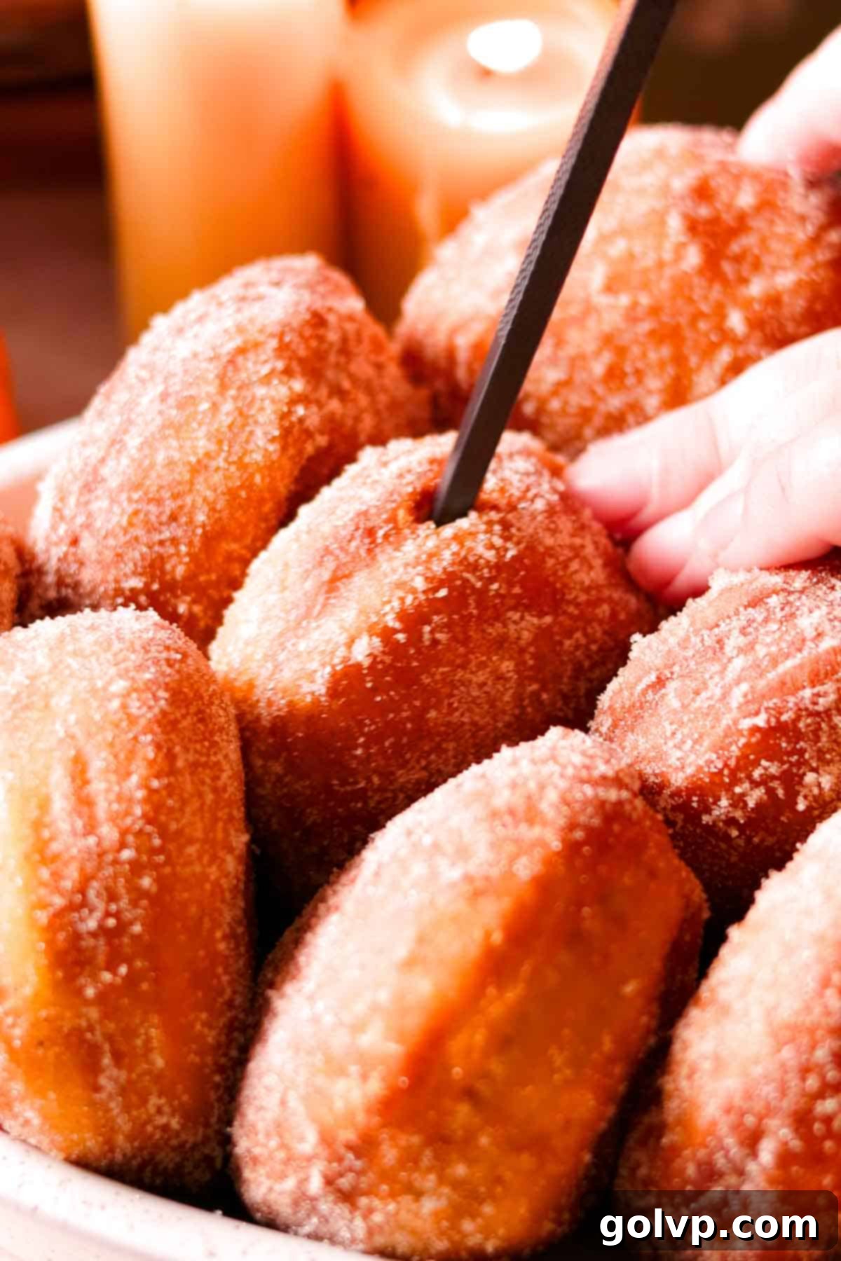 poking holes inside the fried and cooled donuts with a chopstick