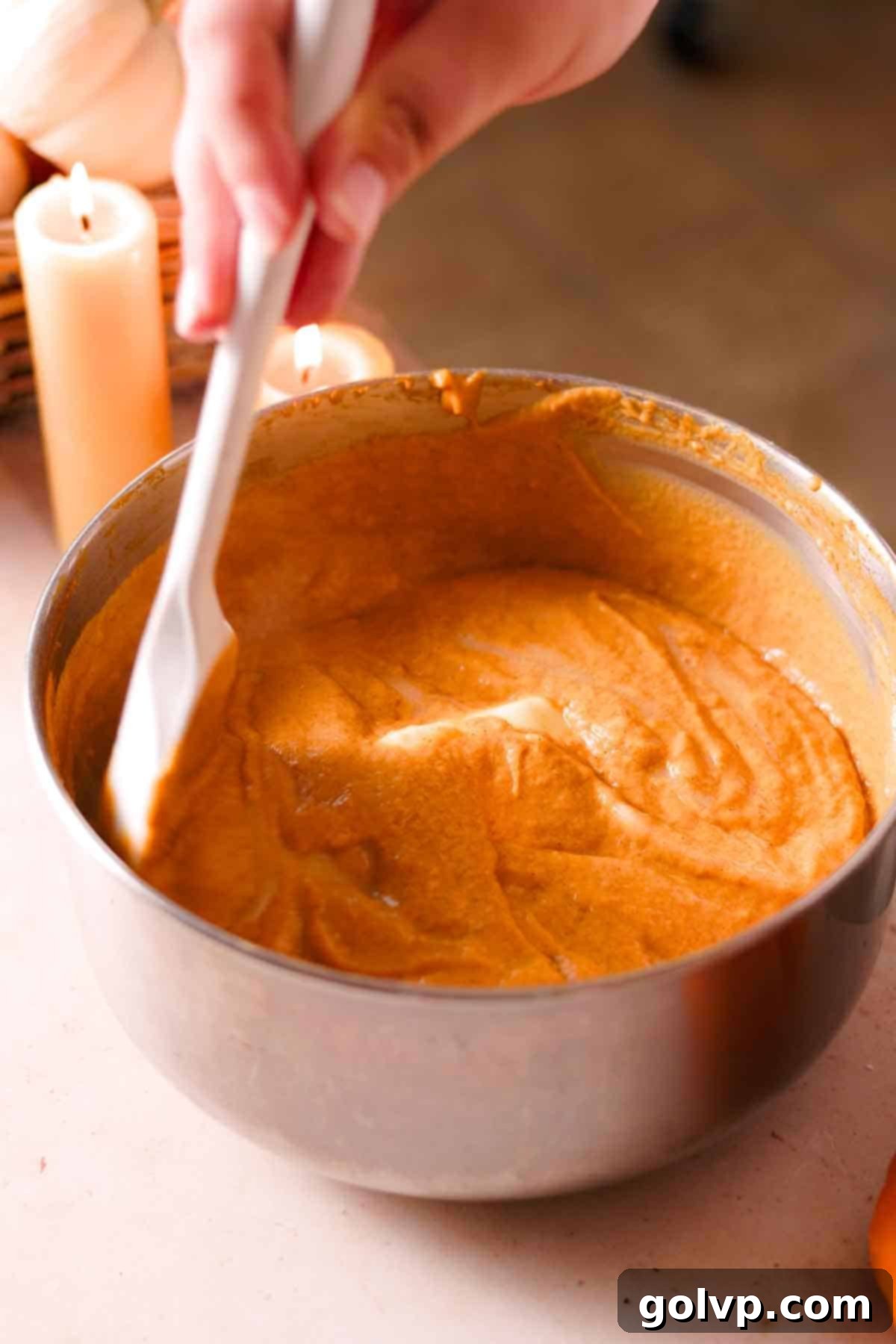stirring butter into a saucepan filled with hot pumpkin custard as it melts