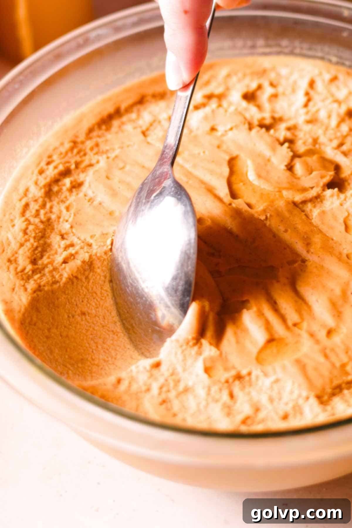 scraping a spoon through the very thick, set pumpkin custard texture