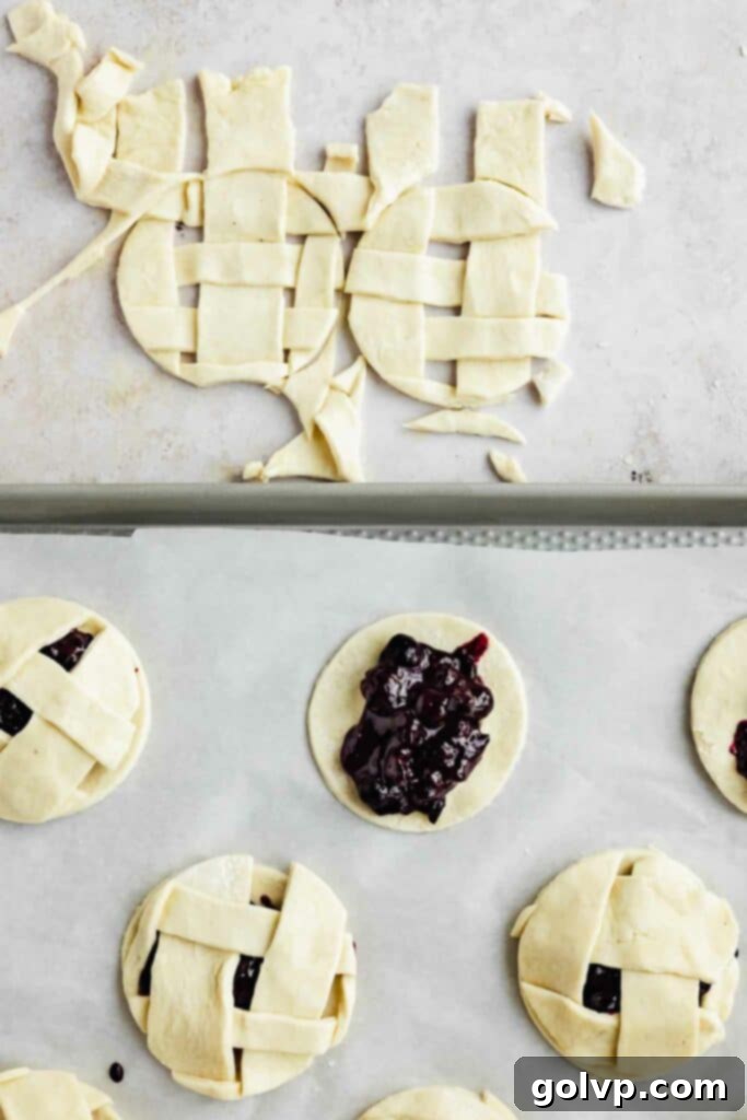 Filling the mini pie crusts with a tablespoon of chilled blueberry filling.
