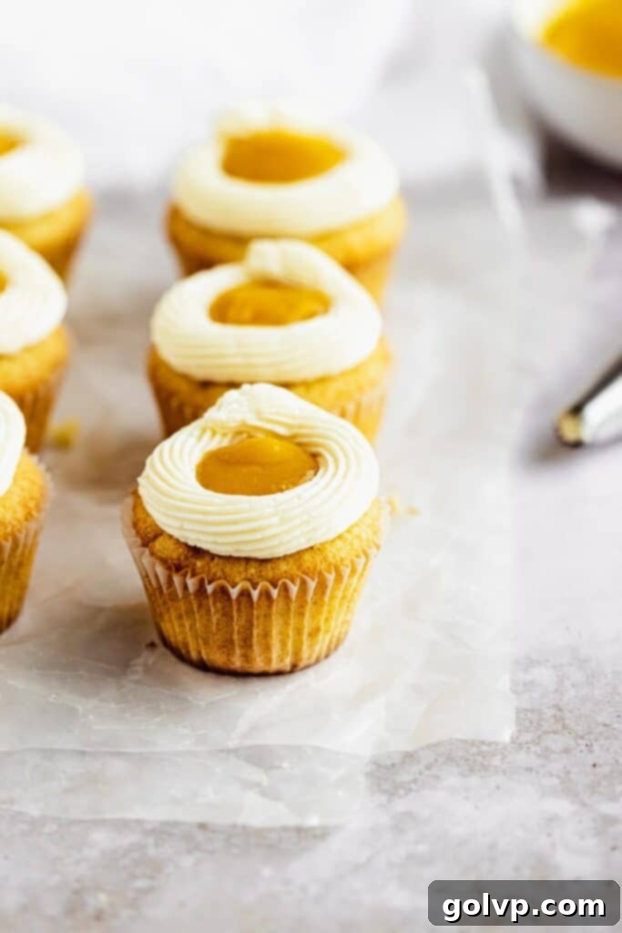 Decorated mango cupcakes that look like sunny side up eggs, with vibrant yellow mango filling and smooth white condensed milk buttercream.