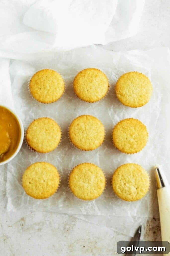 Baked vanilla cupcakes cooling, ready for the mango filling.