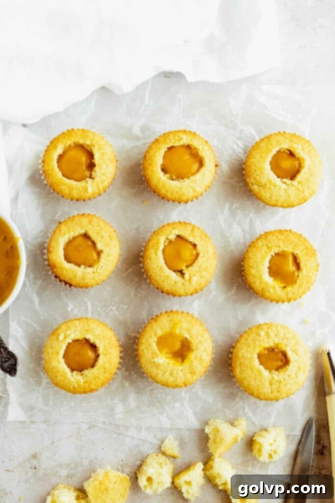 Cupcakes being carefully filled with luscious, homemade mango puree.