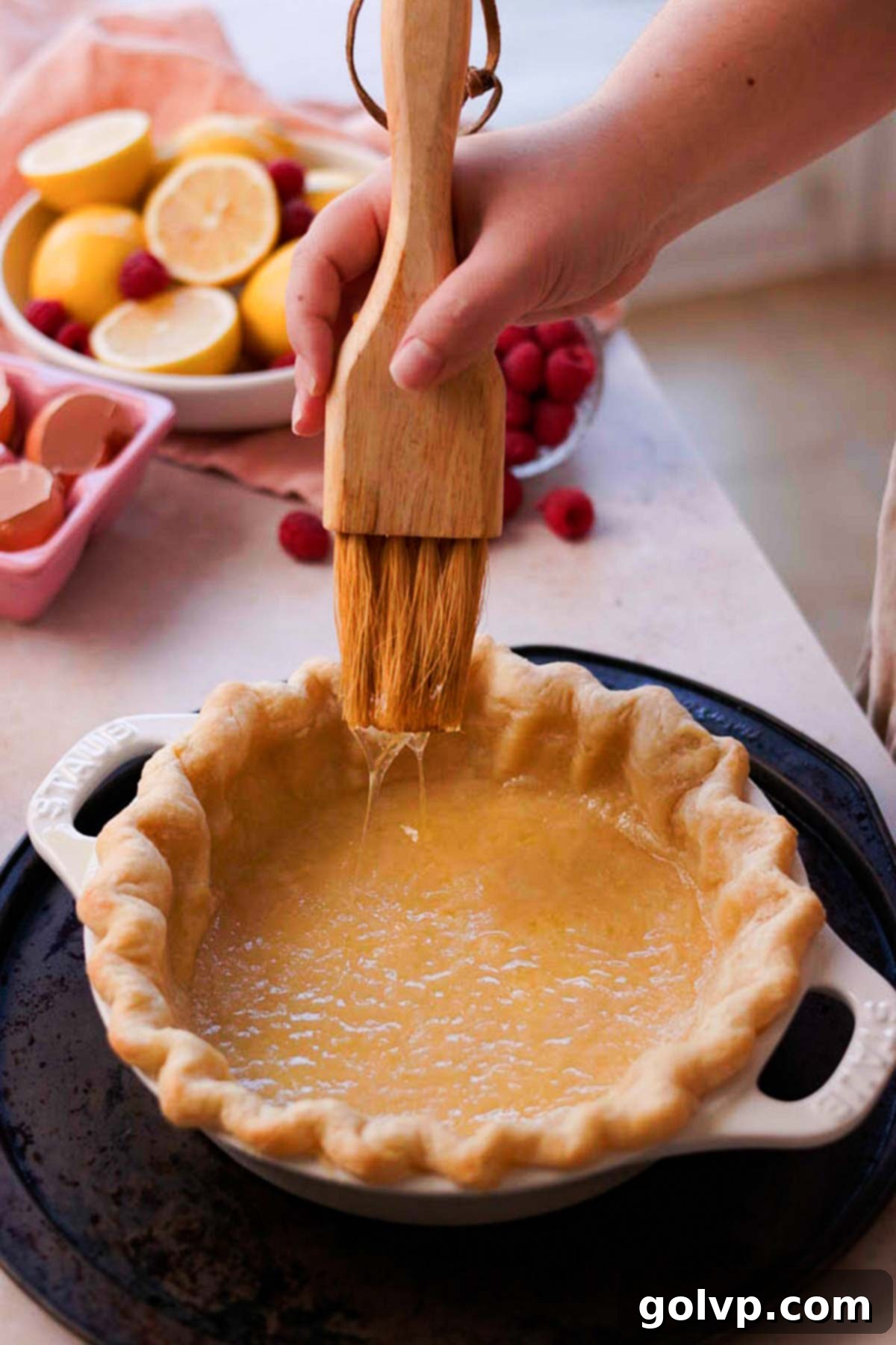 brushing inside of pie crust with egg whites