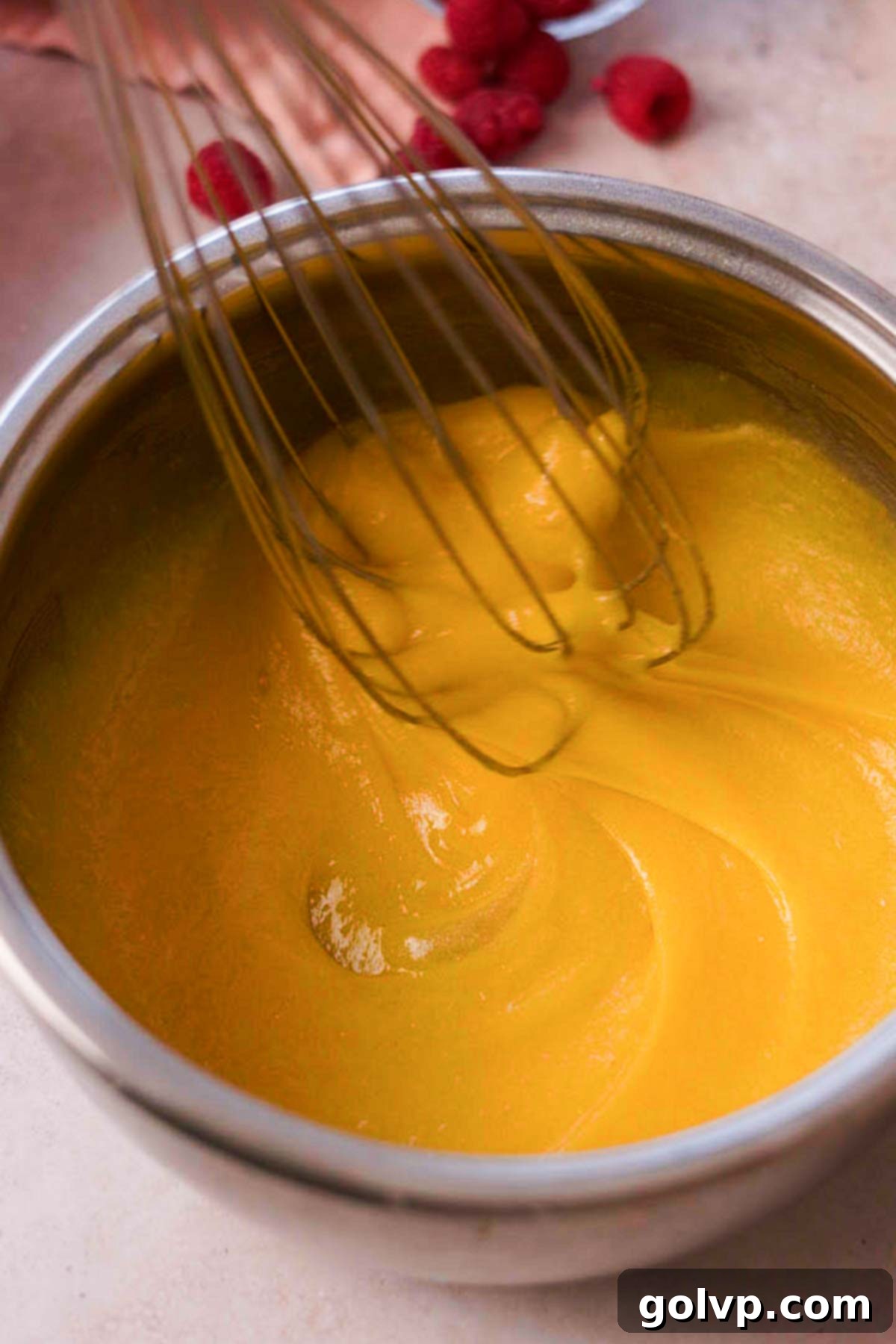 whisking eggs and sugar for raspberry pie filling in pot