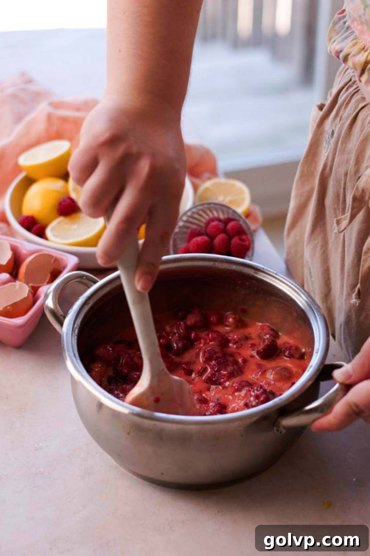 stirring raspberry pie filling inside of pot