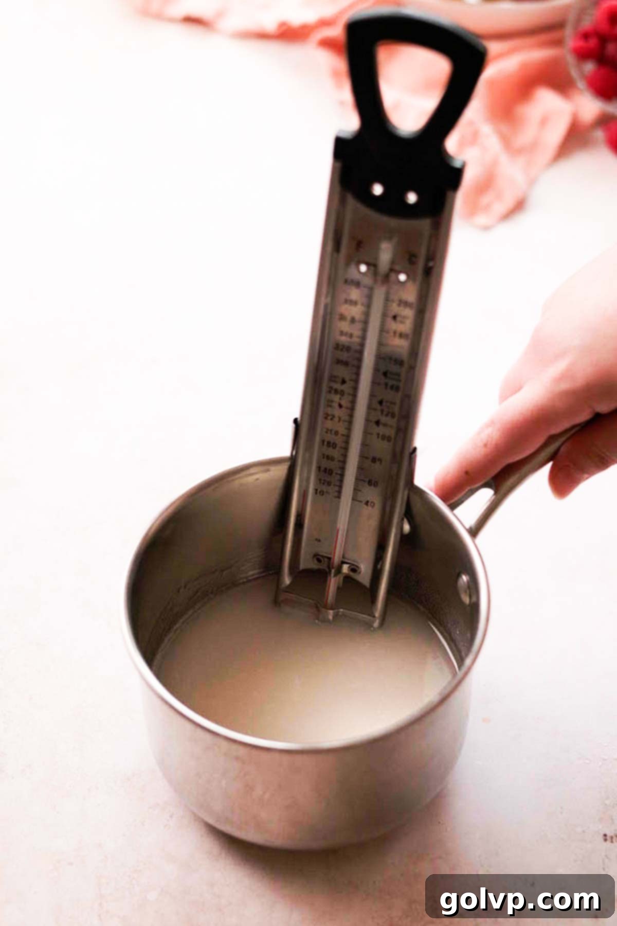 small saucepan with candy thermometer filled with sugar and water