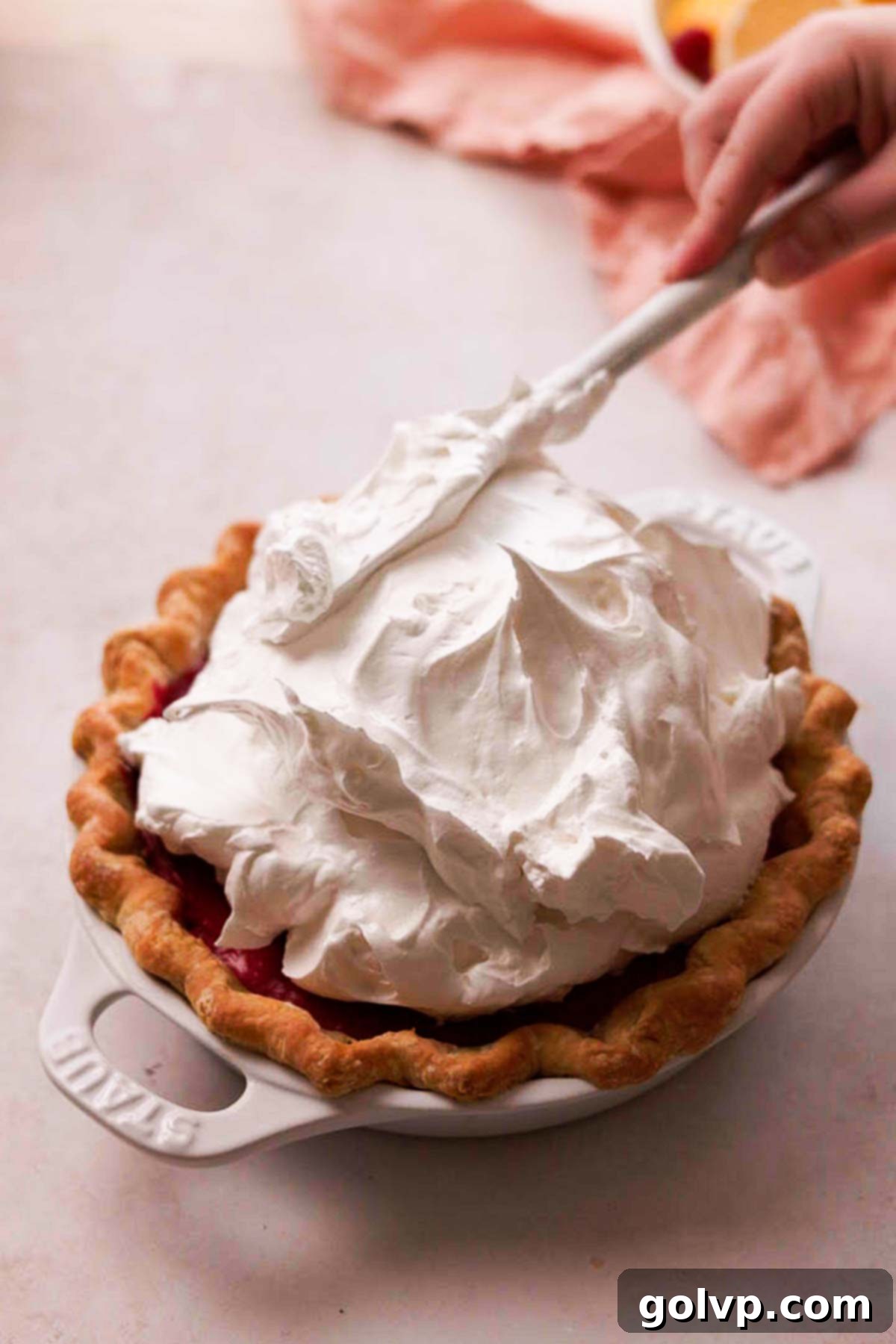topping raspberry pie with lots of meringue
