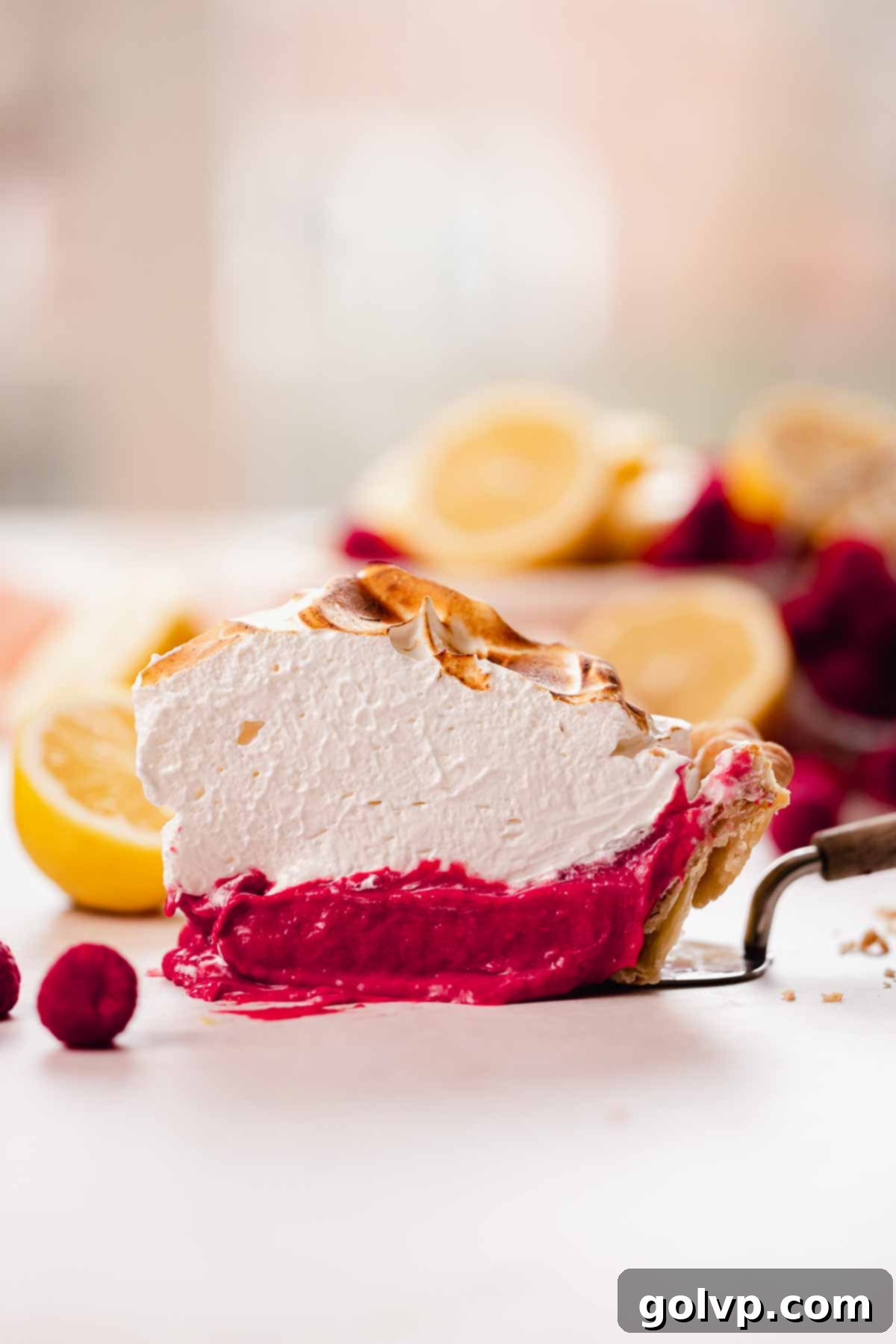 slice of raspberry meringue pie on pie server