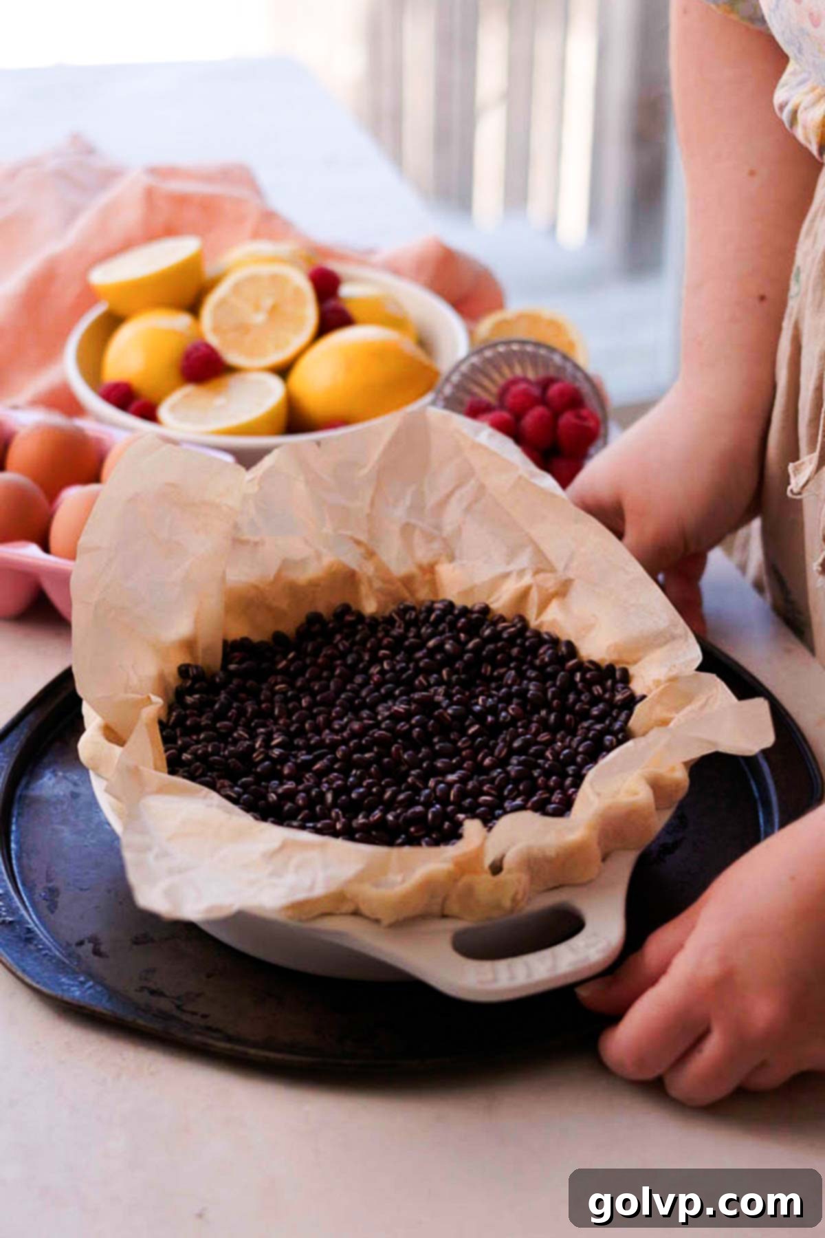 parchment paper inside of pie crust with baking beans