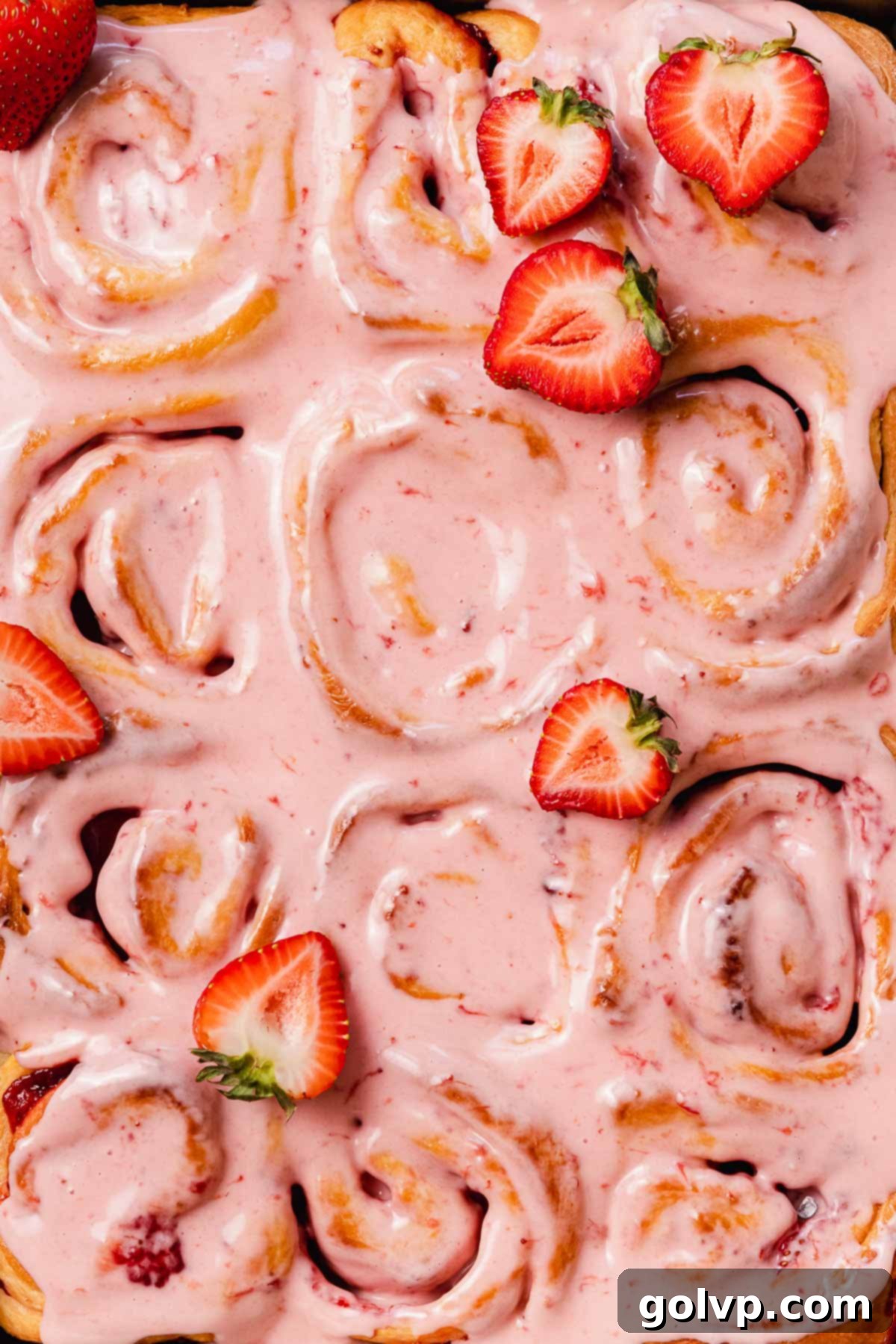 Fresh Strawberry Cinnamon Swirls 2 Delicious freshly baked strawberry cinnamon rolls topped with a generous layer of pink strawberry cream cheese glaze and garnished with fresh strawberry slices.