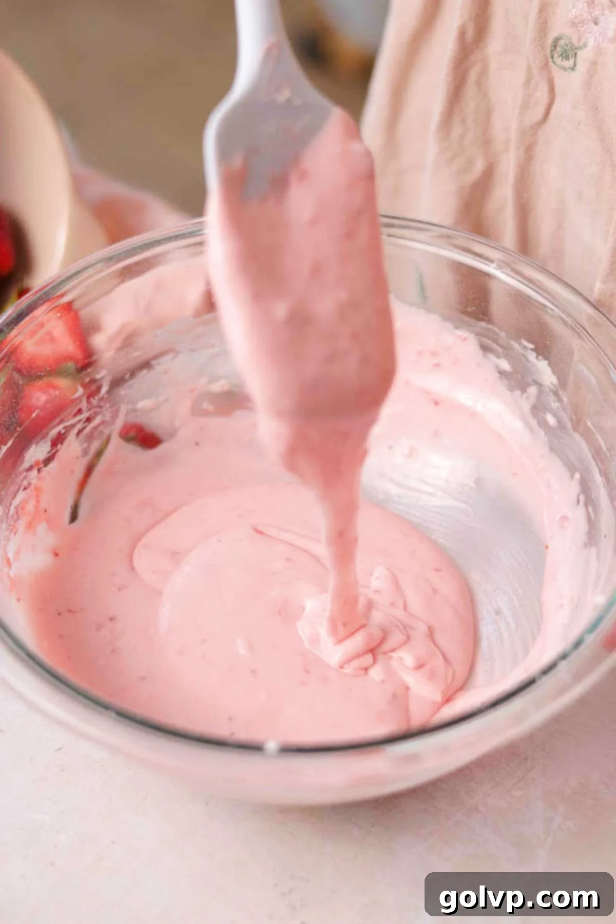 Fresh Strawberry Cinnamon Swirls 18 Smooth, runny pink strawberry cream cheese glaze in a bowl after being mixed.