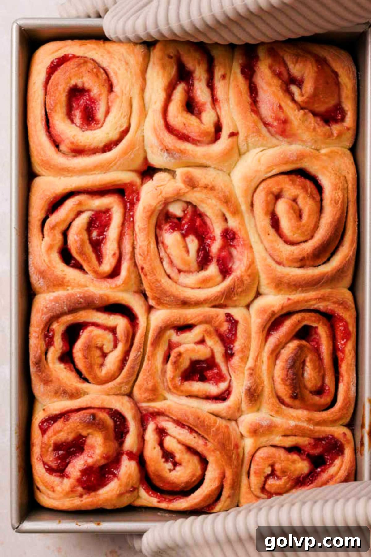 Fresh Strawberry Cinnamon Swirls 19 Freshly baked golden brown strawberry cinnamon rolls in a baking pan, just out of the oven.