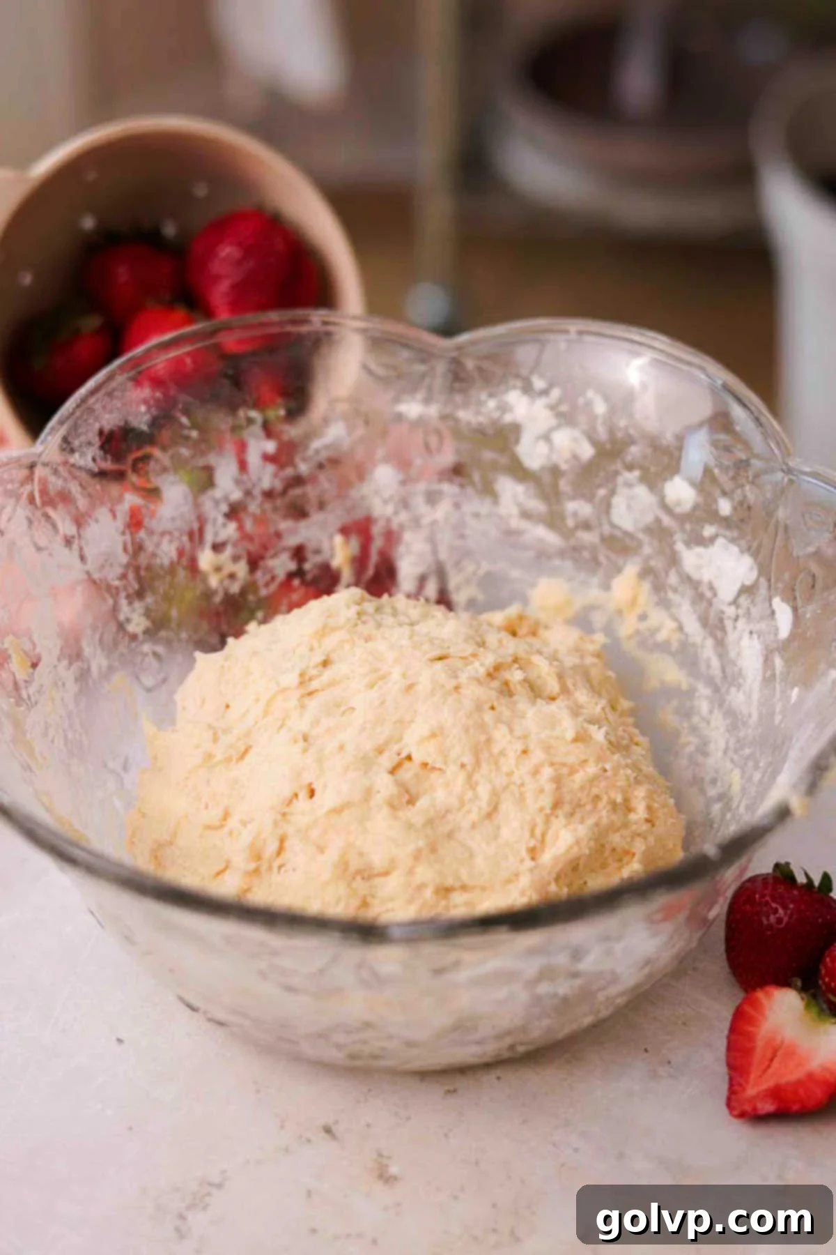 Fresh Strawberry Cinnamon Swirls 9 A sticky, cohesive ball of dough resting in a large glass bowl after initial mixing.
