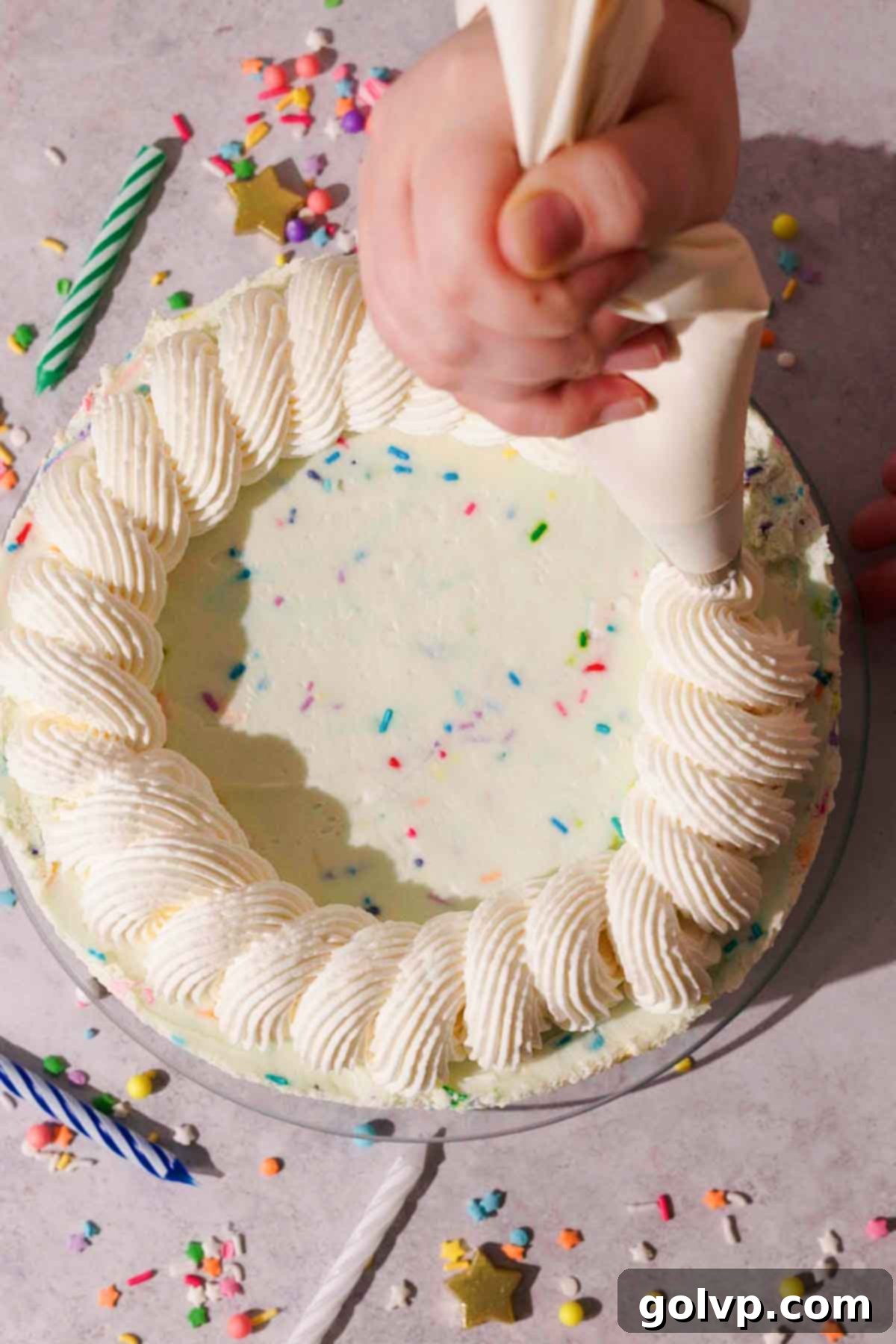 piping a rope border with a piping bag on top of the cheesecake
