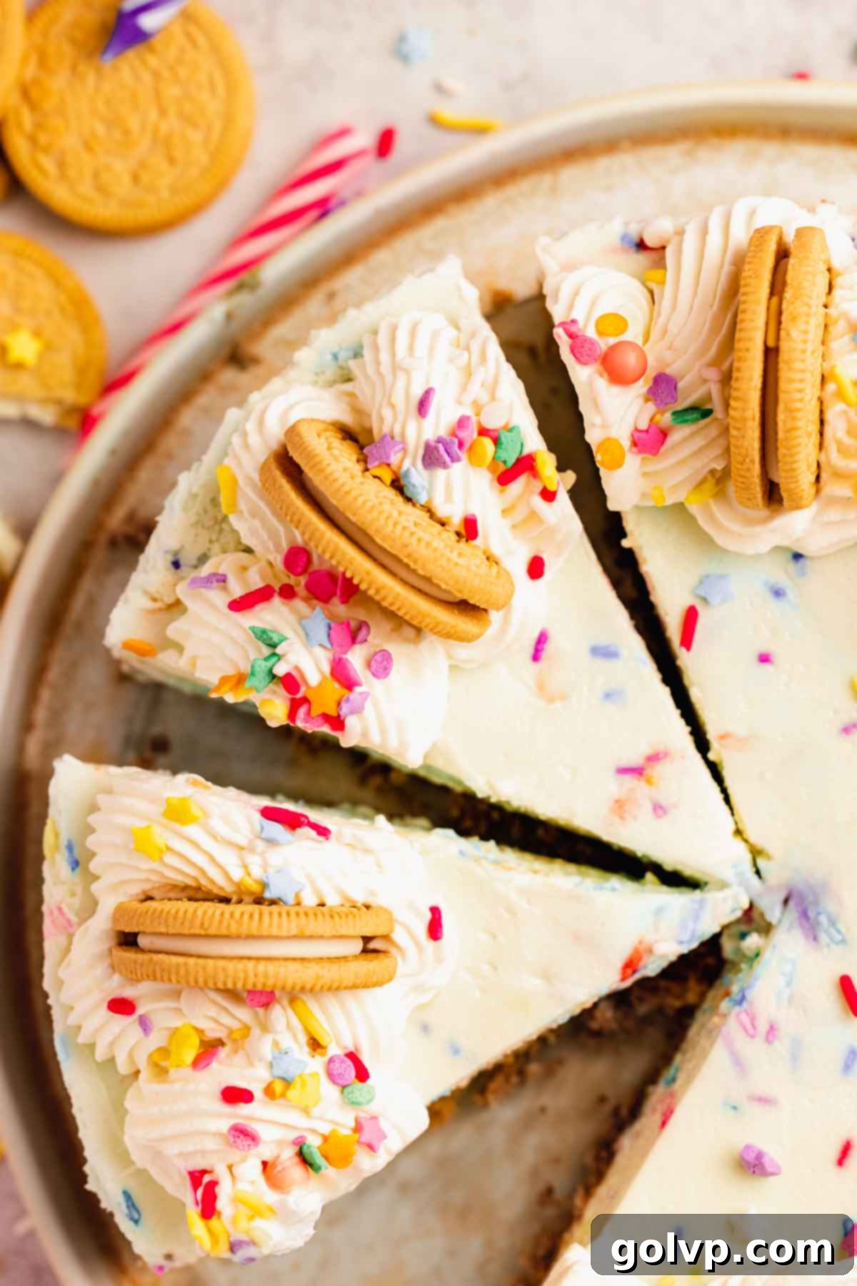 cheesecake with piped border, golden oreos, and sprinkles