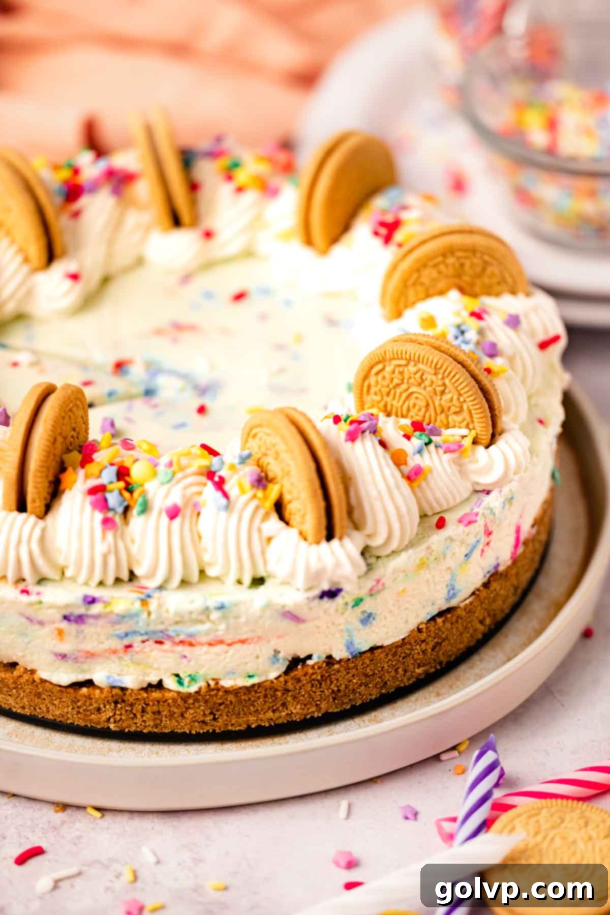 cheesecake on serving plate with golden oreos and sprinkles