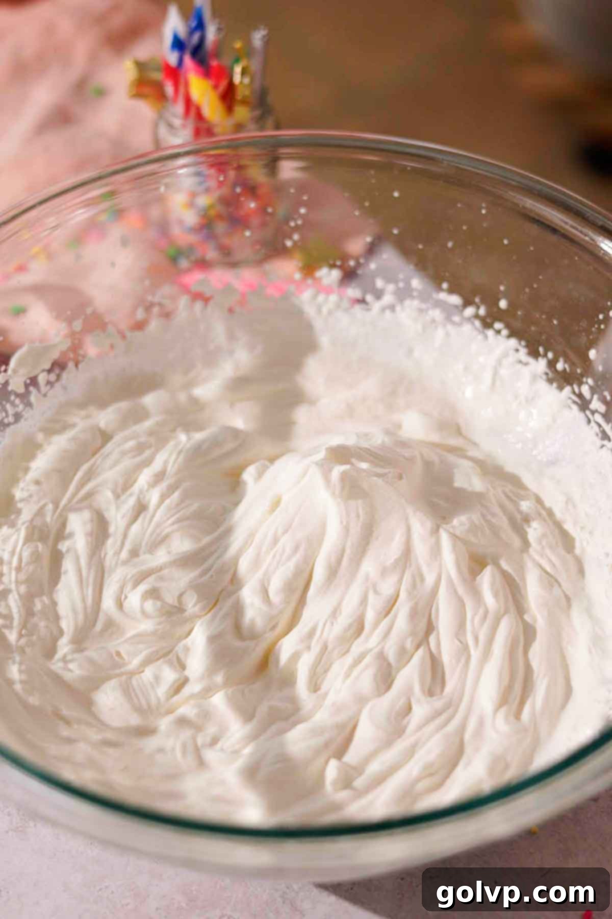 whipping cream whipped to stiff peaks in large glass bowl