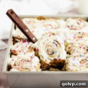 tilted cinnamon roll in baking pan with spatula