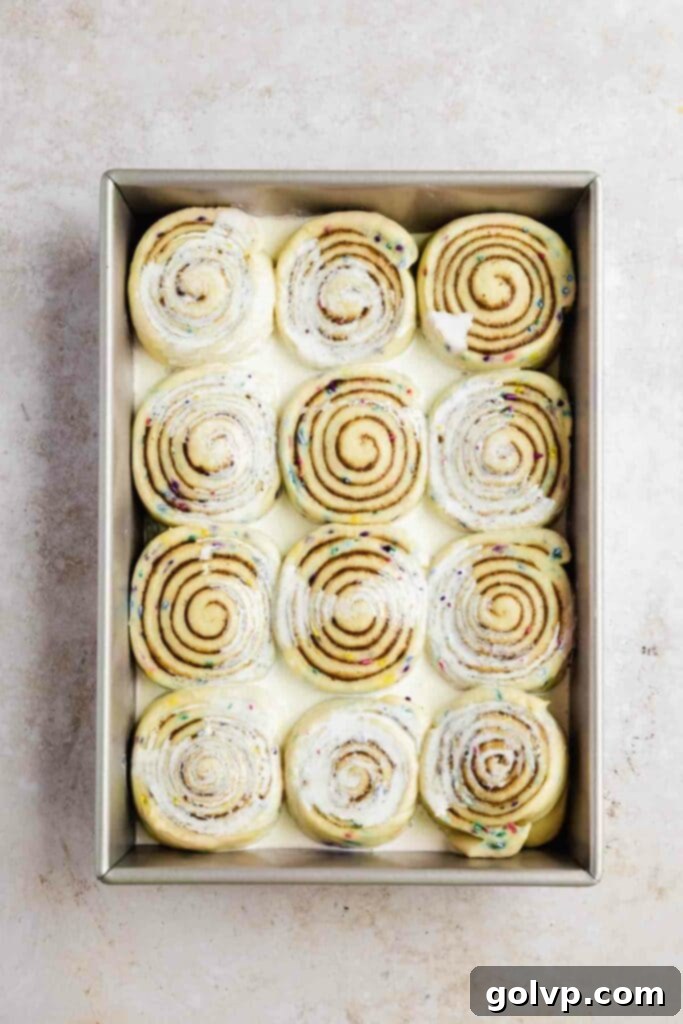 Cream poured onto risen and unbaked cinnamon rolls