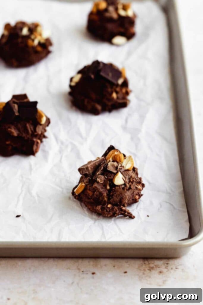 Scooped cookie dough balls with chocolate and almonds pressed on top