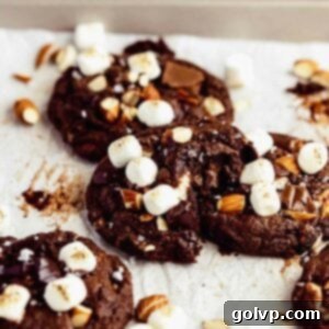 bitten cookie with almonds and marshmallows on cookie tray with parchment paper